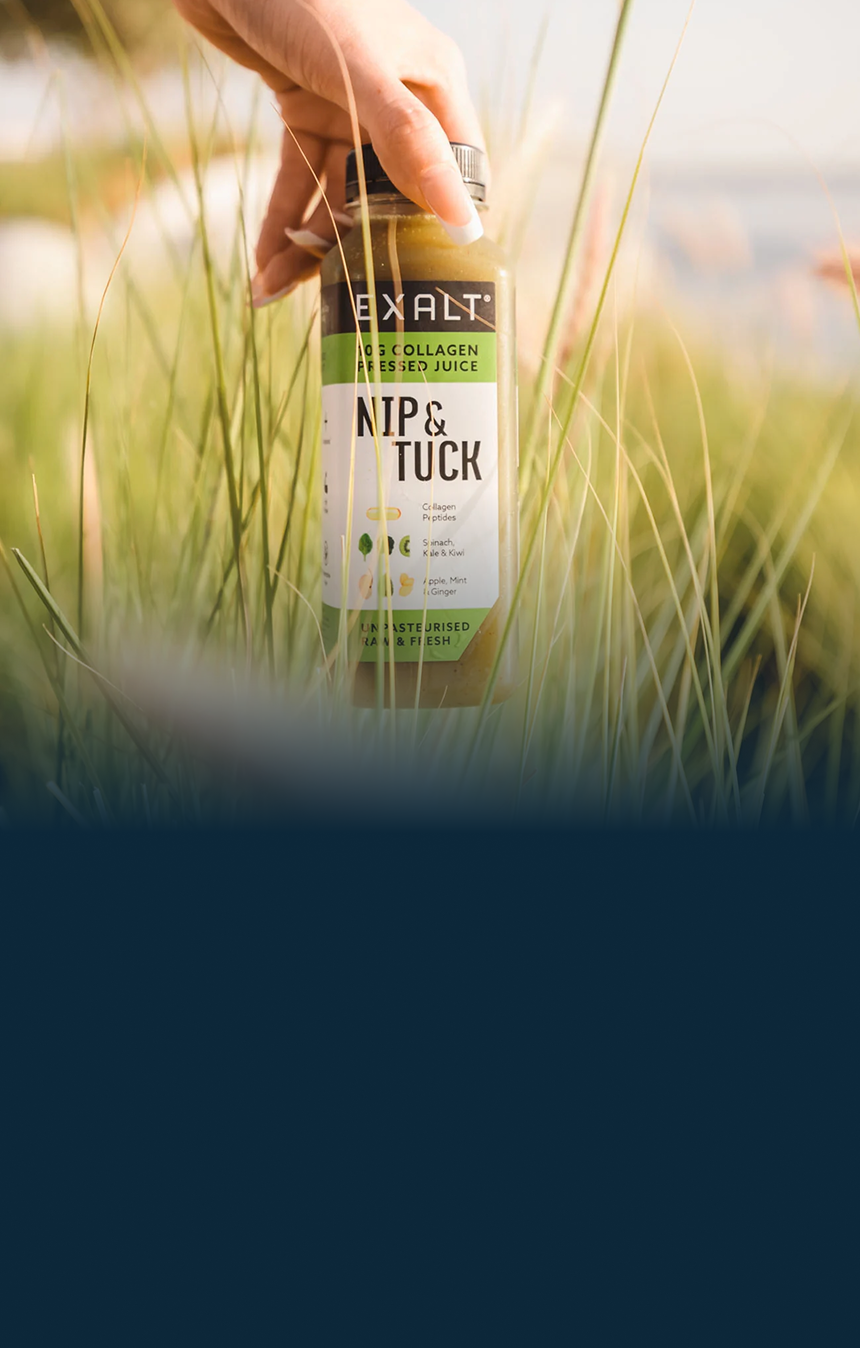 EXALT bottle held in long grass