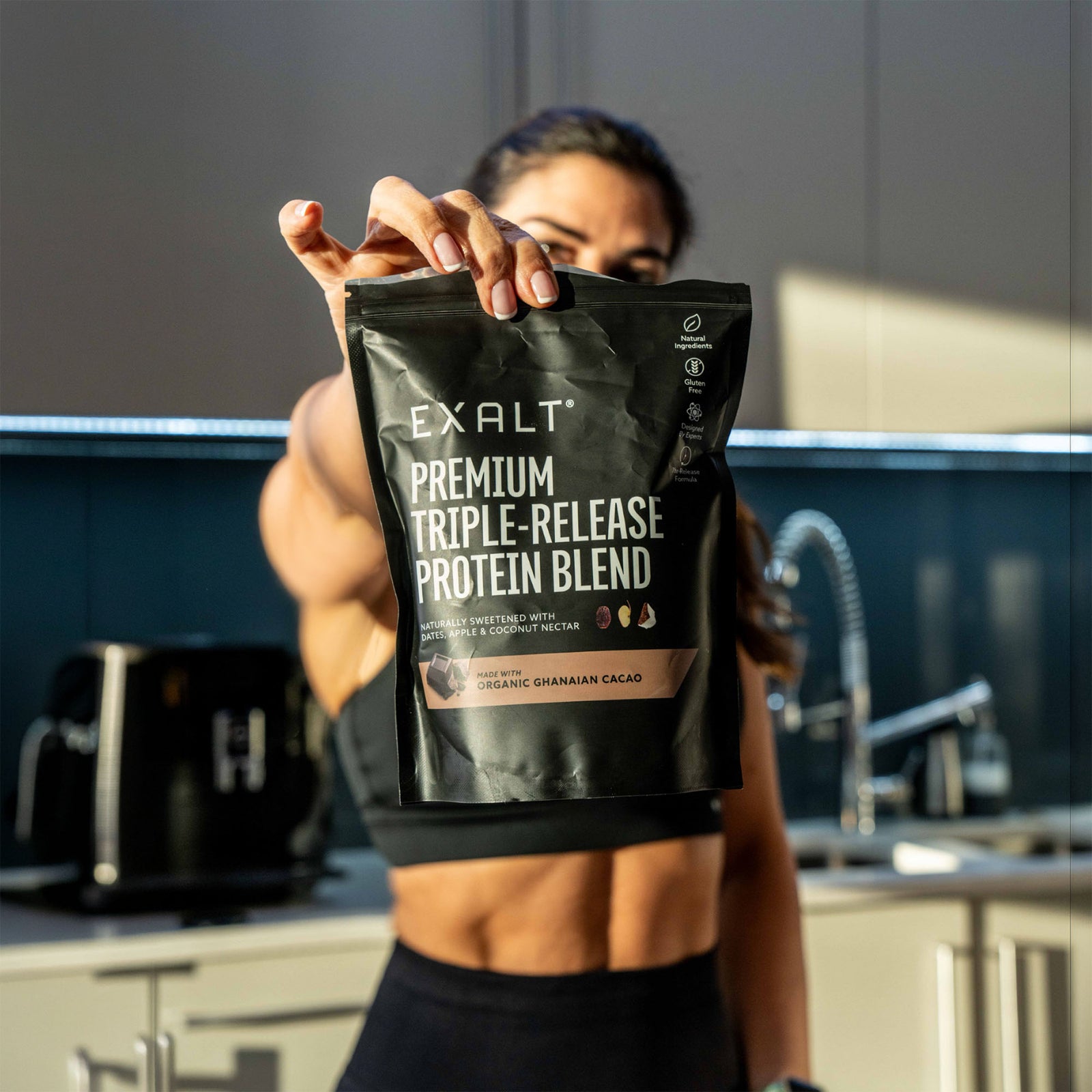 Two people holding EXALT protein drinks